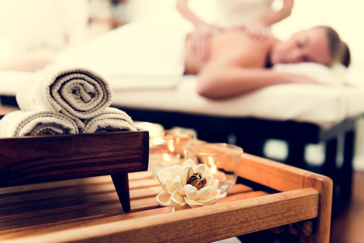 Massageruimte met opgerolde handdoeken en kaarsen