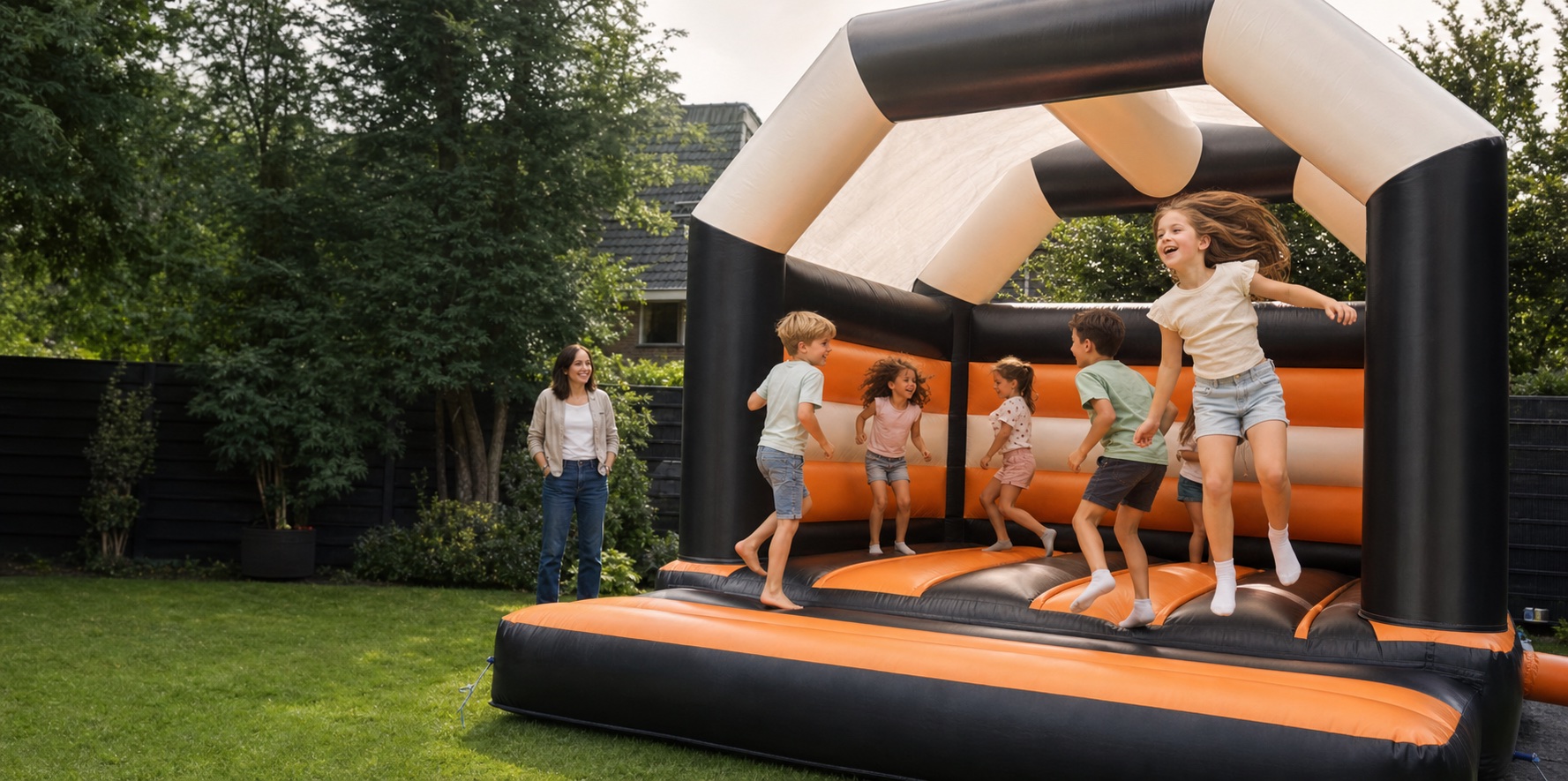 Kinderen spelen onder toezicht op een springkussen in een tuin